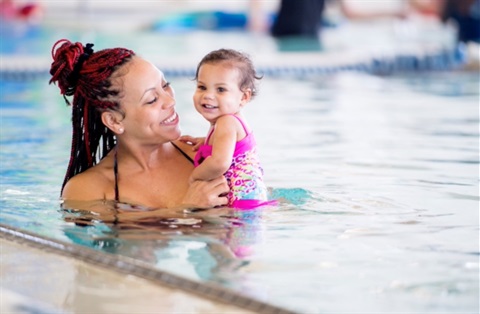Adult holding a child in a pool